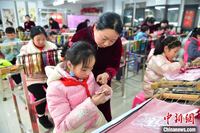 江西省級非遺豫章繡傳承人手把手指導小學生繡制2022年北京冬奧會吉祥物“冰墩墩”形象?！∮髟屏?攝