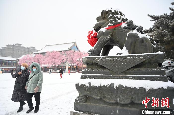 2月13日，民眾在呼和浩特市大召廣場雪中漫步?！⑽娜A 攝