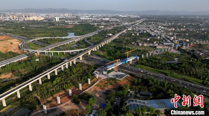 航拍正在建設(shè)的跨越成都繞城高速公路連續(xù)梁施工現(xiàn)場，旁邊依次為已運(yùn)營的成渝高速鐵路和機(jī)場高速公路。　劉忠俊 攝