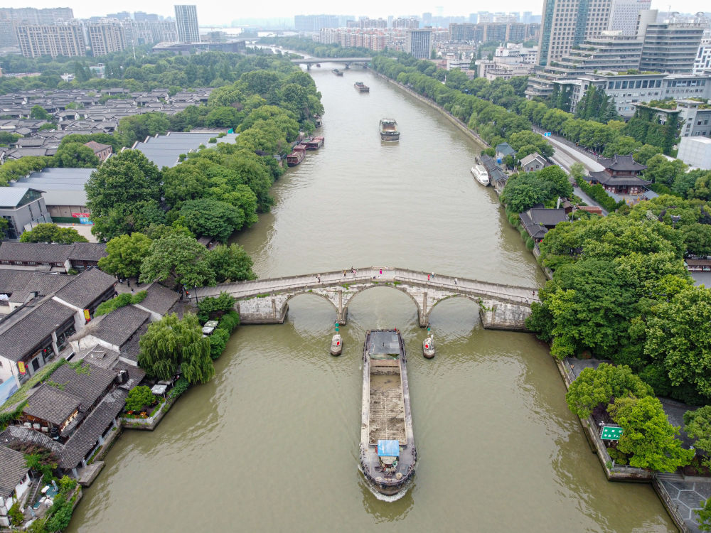 5月27日，一艘貨船駛過京杭大運(yùn)河南端標(biāo)志建筑杭州拱宸橋。(無人機(jī)照片)新華社記者江漢 攝