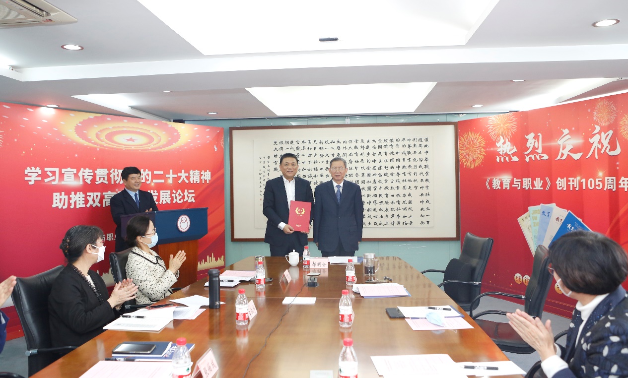 郝明金為《教育與職業(yè)》雜志編委代表陳曉明頒發(fā)聘書。中華職教社供圖