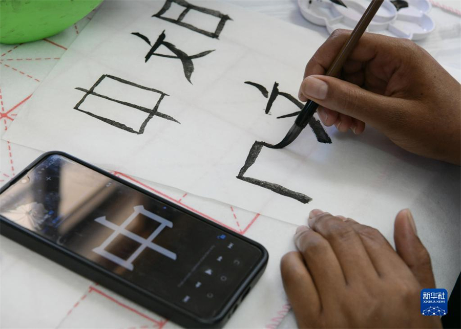 4月18日，肯尼亞學(xué)生在內(nèi)羅畢大學(xué)孔子學(xué)院舉辦的活動(dòng)上寫毛筆字?？夏醽唭?nèi)羅畢大學(xué)孔子學(xué)院18日舉辦“中文，增進(jìn)文明對(duì)話”主題活動(dòng)，慶祝即將到來的第14個(gè)聯(lián)合國(guó)中文日。肯尼亞學(xué)生參與互動(dòng)，進(jìn)行書法、剪紙、唱中文歌等活動(dòng)。新華社記者 韓旭 攝
