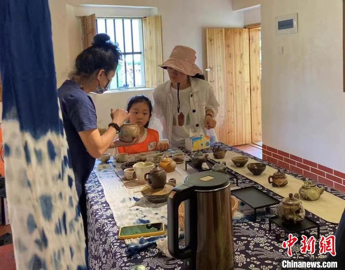 圖為：游客正在咨詢臺灣柴燒作品?！∪~秋云 攝