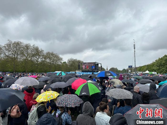 當?shù)貢r間5月6日，英國國王查爾斯三世的加冕儀式舉行。民眾雨中觀看儀式。　歐陽開宇 攝