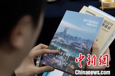 參展觀眾閱讀浙江文旅手冊?！《≌裾?攝