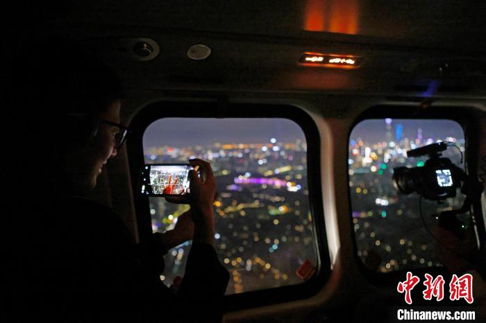 6月3日晚，游客乘坐上海新空直升機(jī)有限公司直升機(jī)開(kāi)啟鳥(niǎo)瞰黃浦江空中圓夢(mèng)之旅，并用手機(jī)拍攝城市夜景。　殷立勤 攝