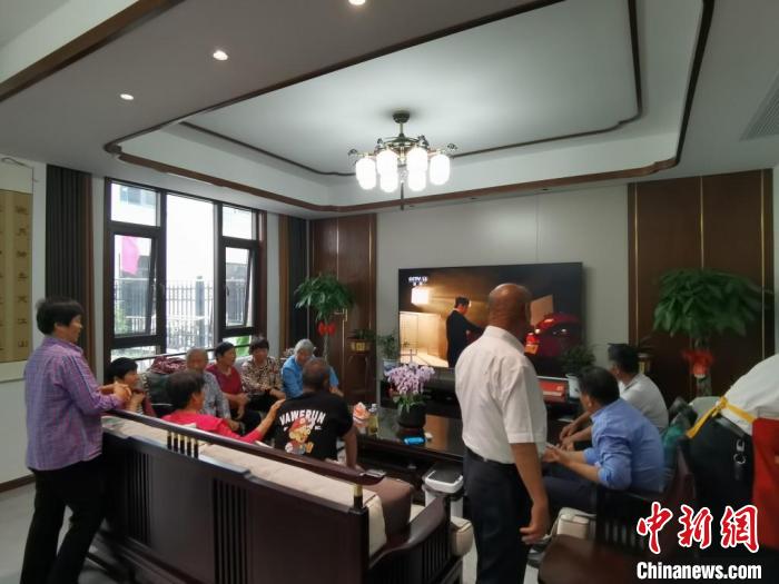 親友們集中在費(fèi)俊龍家中觀看返程的視頻?！＄娚?攝