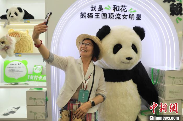 美國華視總裁楊蓮花與大熊貓文創(chuàng)產(chǎn)品合影?！⊥趵?攝