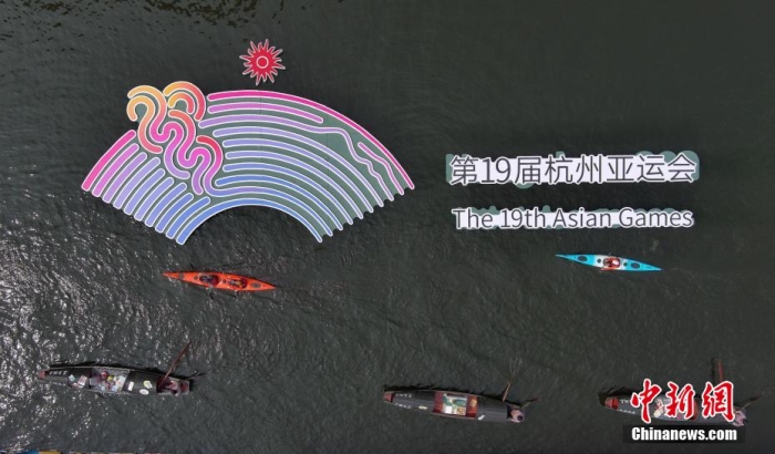 資料圖為烏篷船和皮劃艇從杭州亞運會標識前劃過。王剛 攝
