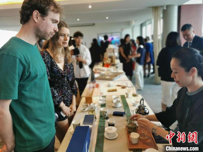 現(xiàn)場(chǎng)觀眾觀看中國(guó)展臺(tái)茶藝表演、了解茶文化。　靖樹 攝