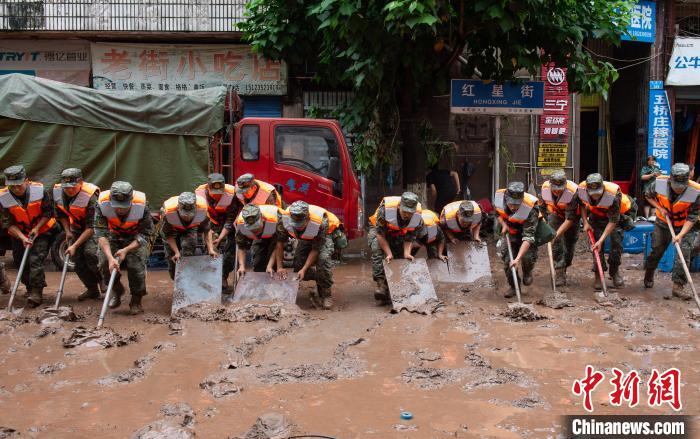 7月4日，萬州區(qū)五橋街道，武警官兵清理街道上的淤泥。　冉孟軍 攝