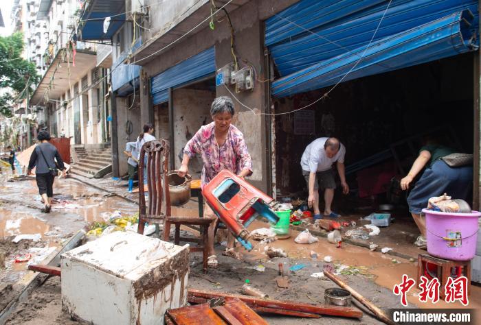 7月4日，萬州區(qū)五橋街道，洪水退去后，居民搶救生活物資?！∪矫宪?攝