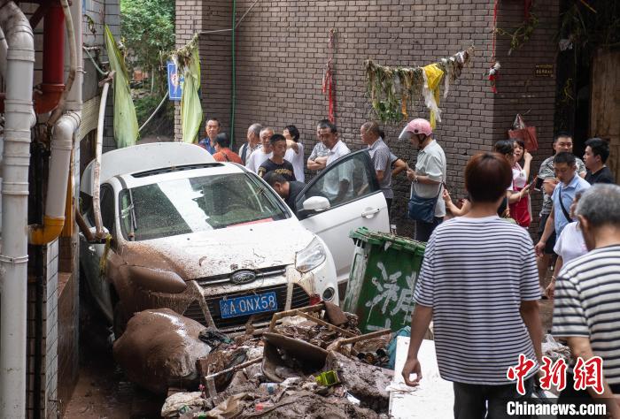 7月4日，萬州區(qū)五橋街道，居民救援受困的私家車。　冉孟軍 攝