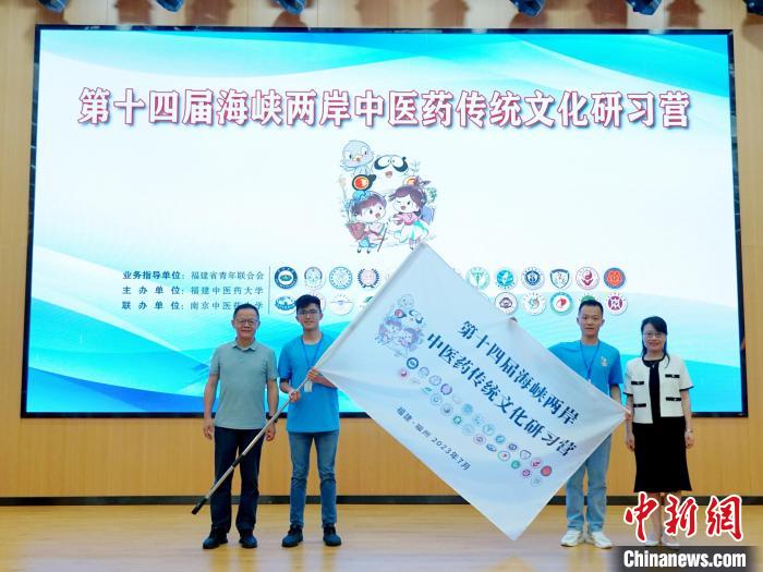 共青團(tuán)福建省委副書記吳雪(右一)、福建中醫(yī)藥大學(xué)黨委副書記林羽(左一)為兩岸學(xué)生代表頒授營旗。　許燁婷 攝