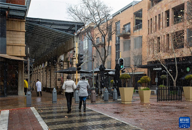 7月10日，在南非約翰內(nèi)斯堡一處商業(yè)區(qū)，人們在雪中行走。新華社記者 張譽(yù)東 攝