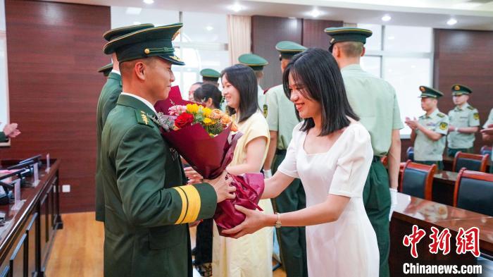 軍屬向晉升警官獻(xiàn)花。　張煜梁 攝