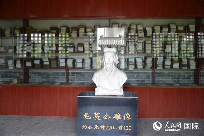 河間詩(shī)經(jīng)齋毛萇雕像。雕像后書(shū)櫥中陳列的是歷代各版本《詩(shī)經(jīng)》及譯本。 人民網(wǎng) 趙昭攝