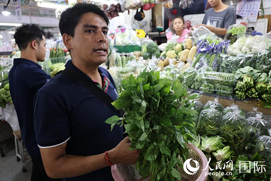 7月19日，泰國曼谷藍(lán)象餐廳員工向參加活動(dòng)的多國代表介紹如何挑選新鮮蔬菜。 人民網(wǎng)記者 張矜若攝