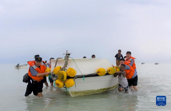 7月21日，中國海軍“和平方舟”號醫(yī)院船醫(yī)護人員涉水登島，前往基里巴斯一診療點。新華社記者 黎云 攝