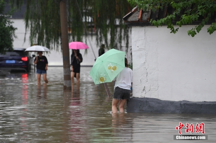 7月31日，市民行走在雨中的北京房山區(qū)瓦窯頭村。北京市氣象臺當日10時發(fā)布分區(qū)域暴雨紅色預警信號。北京市水文總站發(fā)布洪水紅色預警，預計當日12時至14時，房山區(qū)大石河流域?qū)⒊霈F(xiàn)紅色預警標準洪水。<a target='_blank' href='/'><p  align=