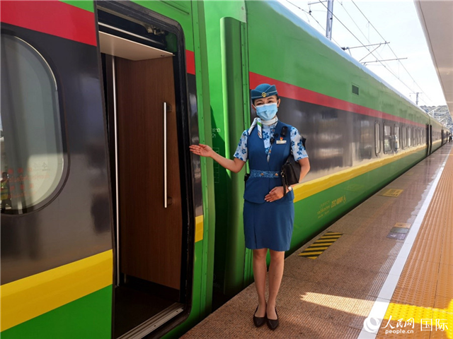 趙瑩靜站在“復(fù)興號(hào)”國(guó)際旅客列車車廂門口歡迎旅客上車。人民網(wǎng) 杜明明攝