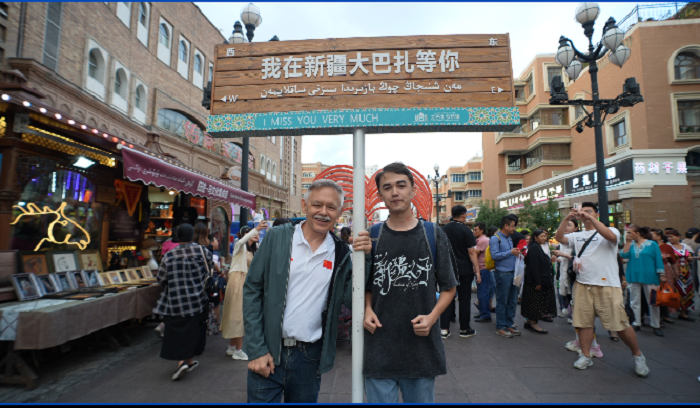 潘維廉和維吾爾族青年伊木蘭“打卡”大巴扎。主辦方供圖