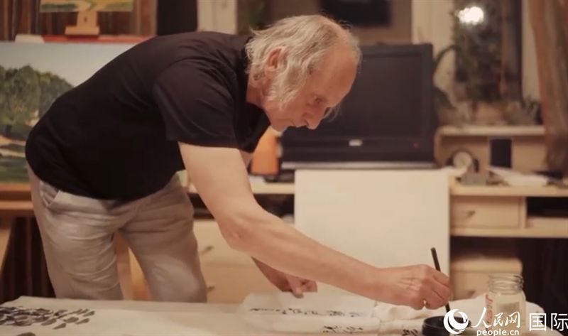 伊戈?duì)枴げ紶枛|諾夫在畫作上題詞。人民網(wǎng)記者 馬天翼攝