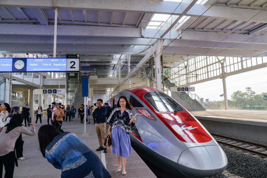 10月17日，在印度尼西亞萬(wàn)隆德卡魯爾站，乘客在站臺(tái)上和雅萬(wàn)高鐵高速動(dòng)車(chē)組列車(chē)合影。