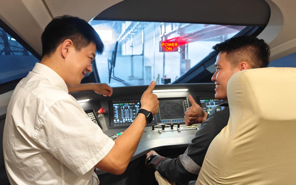 8月25日，在印度尼西亞萬(wàn)隆的雅萬(wàn)高鐵德卡魯爾動(dòng)車(chē)所內(nèi)，中國(guó)師傅穆振（左）在向印尼火車(chē)司機(jī)塞蒂亞萬(wàn)講解動(dòng)車(chē)組出庫(kù)前的上電作業(yè)。