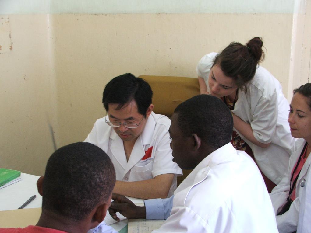 2011年7月22日，在坦桑尼亞桑給巴爾納茲莫加醫(yī)院外科門(mén)診，中國(guó)第24批援桑給巴爾醫(yī)療隊(duì)隊(duì)長(zhǎng)盧建林為當(dāng)?shù)鼗颊咴\治并帶教實(shí)習(xí)生。新華社發(fā)（國(guó)家衛(wèi)生健康委供圖）