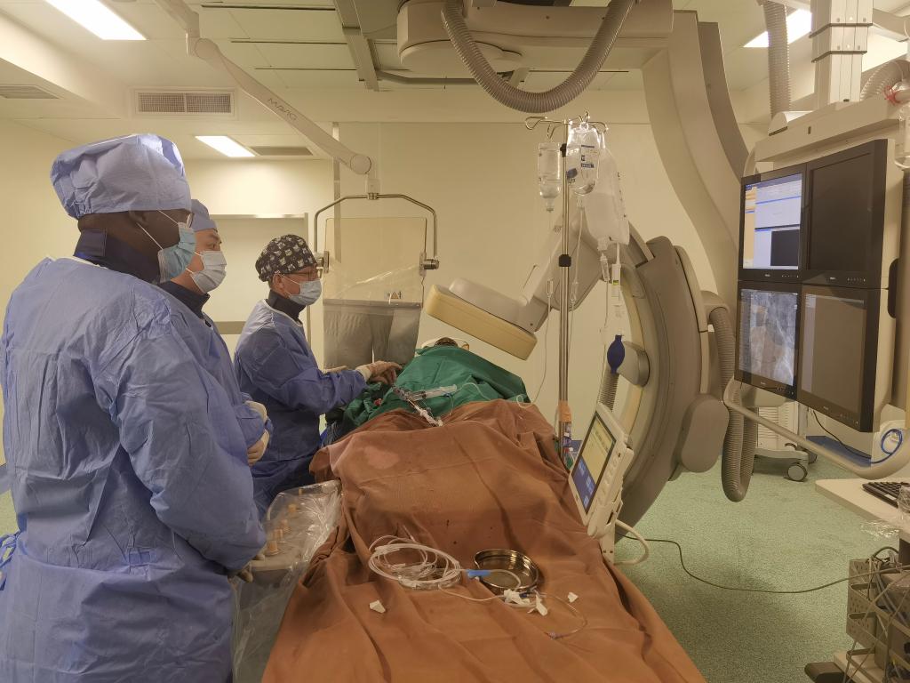 中國(guó)第29批援幾內(nèi)亞醫(yī)療隊(duì)隊(duì)員、首都醫(yī)科大學(xué)附屬北京天壇醫(yī)院心內(nèi)科副主任醫(yī)師王汝朋（右一）正在給患者做手術(shù)。（北京天壇醫(yī)院供圖）