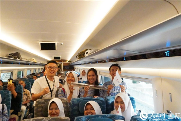 第一次乘坐雅萬高鐵動車組的學生們與動車組模型合影。人民網(wǎng)記者曹師韻攝