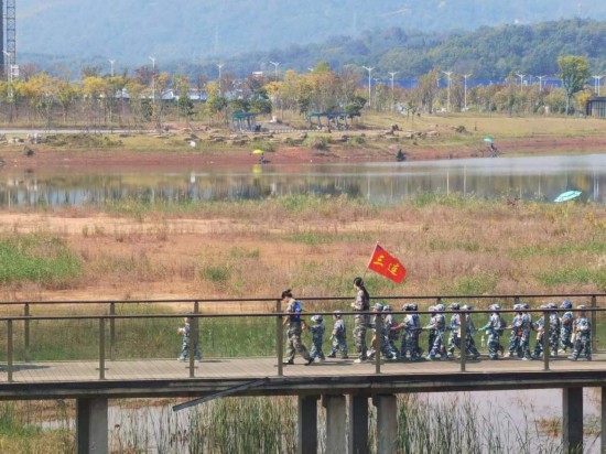 　　10月24日，秋游的幼兒園小朋友在老師帶領(lǐng)下走在清水塘公園里的木橋上。本報(bào)記者 常雯宜攝