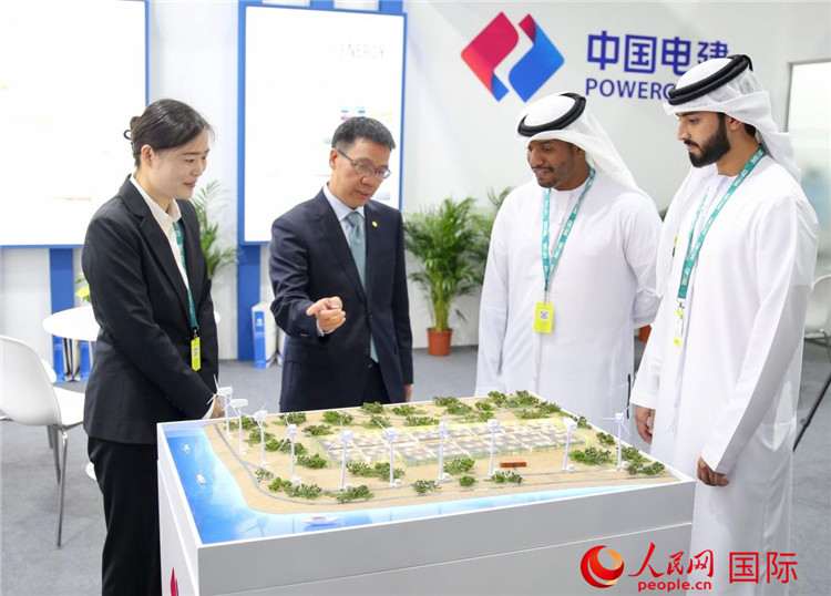 訪客在中國電建展臺參觀風(fēng)電項目沙盤。人民網(wǎng) 塔里克·易卜拉欣攝