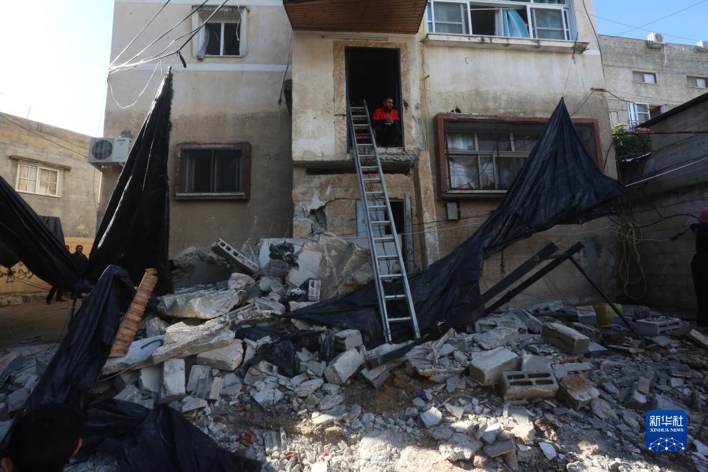 12月17日，在約旦河西岸城市圖勒凱爾姆附近的一處難民營，人們查看在沖突中損毀的房屋。新華社發(fā)（尼達爾·艾仕塔耶攝）