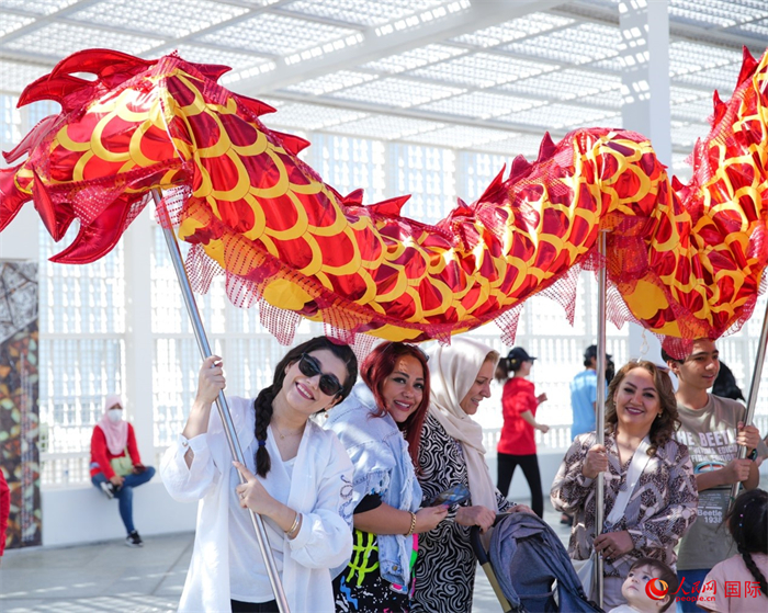 游客體驗(yàn)舞龍。 人民網(wǎng) 塔里克·易卜拉欣攝