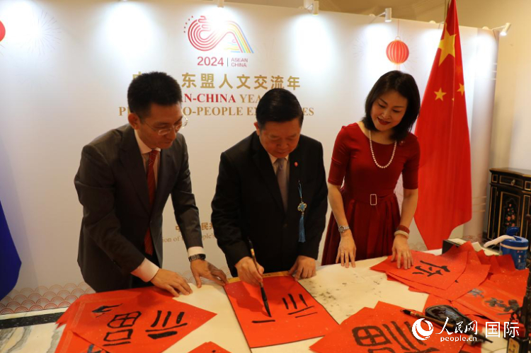 東盟秘書長高金洪（中）在活動現(xiàn)場寫福字。人民網(wǎng)記者曹師韻攝