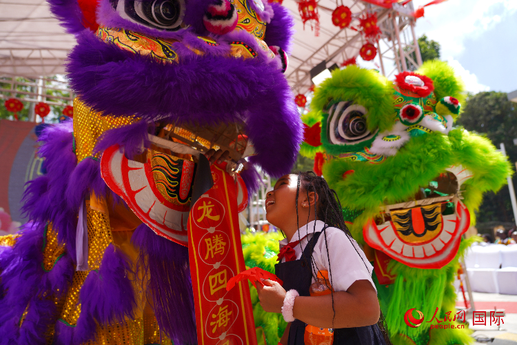 小朋友與舞獅表演者互動。人民網(wǎng)記者 黃煒鑫攝