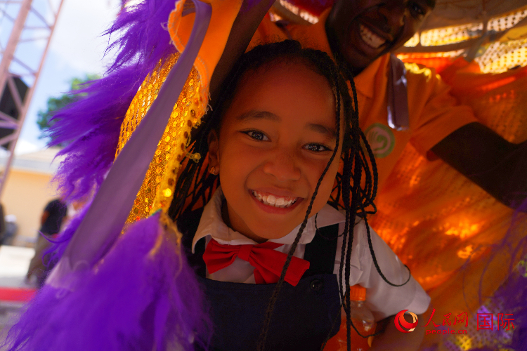 一名小朋友在與舞獅表演者互動。人民網(wǎng)記者 黃煒鑫攝