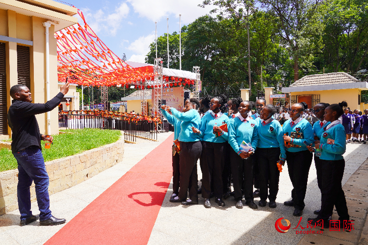 一名老師在給學(xué)生拍照留念。人民網(wǎng)記者 黃煒鑫攝