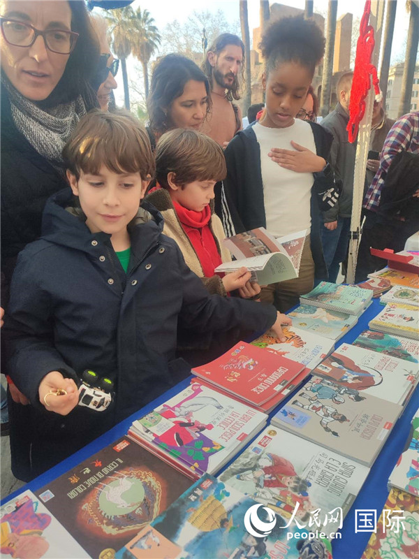 印刷精美的中國傳統(tǒng)文化叢書吸引了小游客的注意。人民網(wǎng)記者鄭彬攝