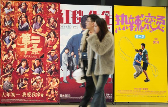 這是2月17日，在沈陽一家影院，觀眾從海報前經(jīng)過。新華社記者李鋼攝