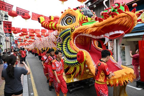 2月1日，由馬來西亞和中國的100多名青少年組成的舞龍隊在馬來西亞馬六甲市雞場街上共舞一條近200米的“長龍”。這是活動現(xiàn)場的“長龍”。新華社記者程一恒攝