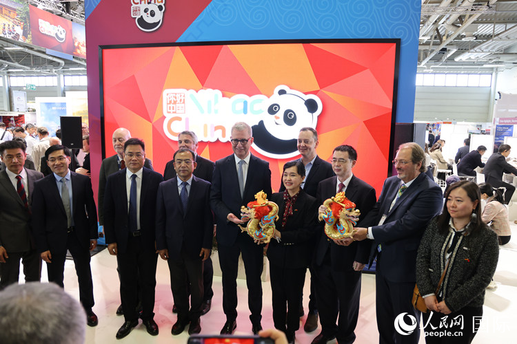 參加中國館開幕式的嘉賓們在“你好 中國” 展臺前合影留念。