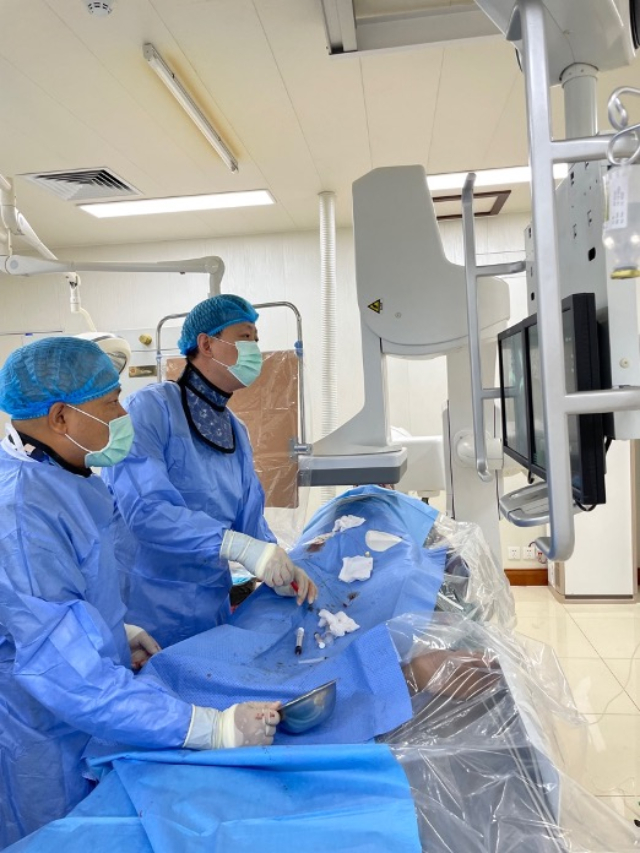 李凱教授（右）和劉海濤教授（左）為患者行TACE手術(shù)。中國駐老撾大使館供圖