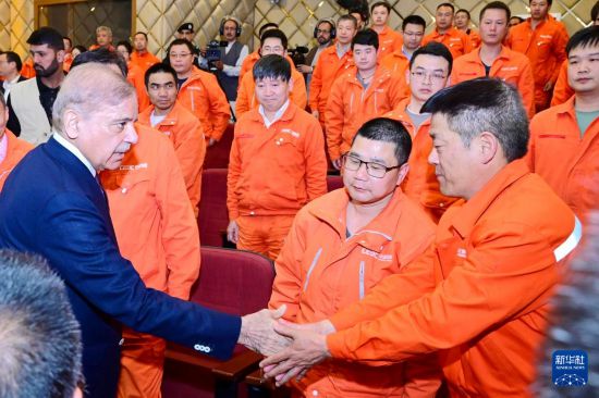 4月1日，在巴基斯坦西北部開伯爾-普什圖省達蘇，巴基斯坦總理夏巴茲（左）同達蘇水電站項目中方員工握手。新華社發(fā)（巴基斯坦新聞與廣播部下轄媒體信息部門供圖）