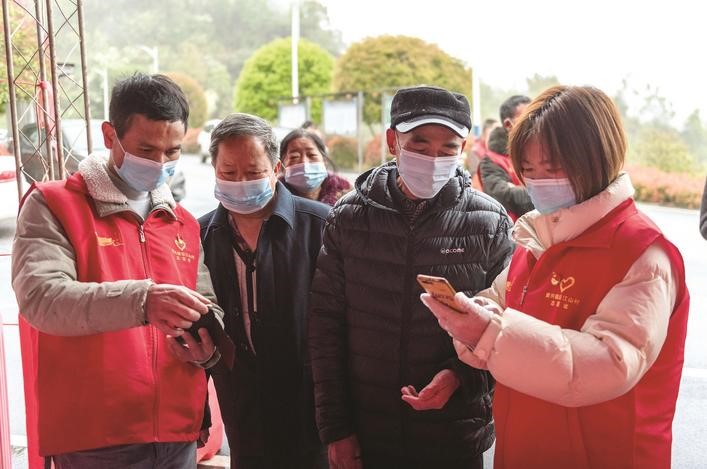長沙縣黨員志愿者正在幫助參與核酸檢測的群眾掃描“場所碼”。劉思源 攝