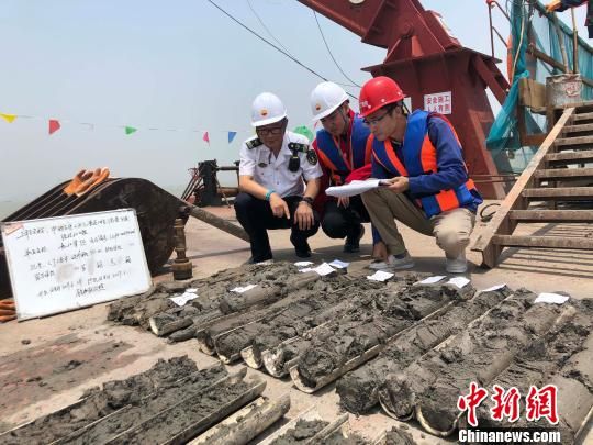 圖為勘察設計人員與海事局工作人員查看巖芯情況?！∥赫?攝