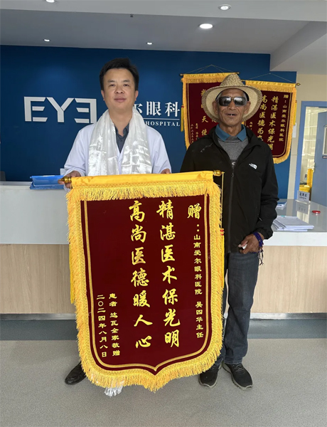 達(dá)瓦老人向吳四華（左）贈送錦旗。受訪者供圖