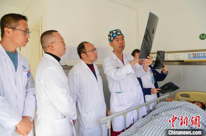 圖為醫(yī)療援藏專家何蔚(站右二)與馮敬云(左二)、廖濤(左三)等人討論患者病情。(資料圖) 貢嘎來松 攝